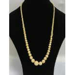 A long ivory graduating necklace.
