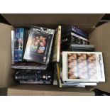 A box containing a collection of various DVDs comp
