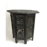 A carved Indian dark wood table of octagonal shape