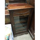 An Edwardian mahogany cabinet fitted with a single