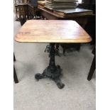 A cast iron table base with wooden top. Measures approx 62cm x 62cm x 70cm.