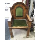 A gothic style wooden arm chair. Measures approx 97cm tall x 46cm deep x 57cm across.