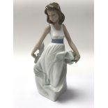 A porcelain Nao figure of a young girl.