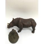 A small bronzed model of a cat looking at a ball o