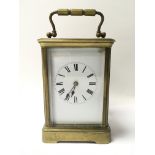 A brass cased carriage clock with white dial prese