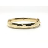 A gold plated bangle, marked M H M.