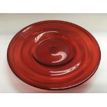 A cranberry glass charger, approx 34cm.