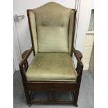 A oak arts and crafts open armchair with green uph