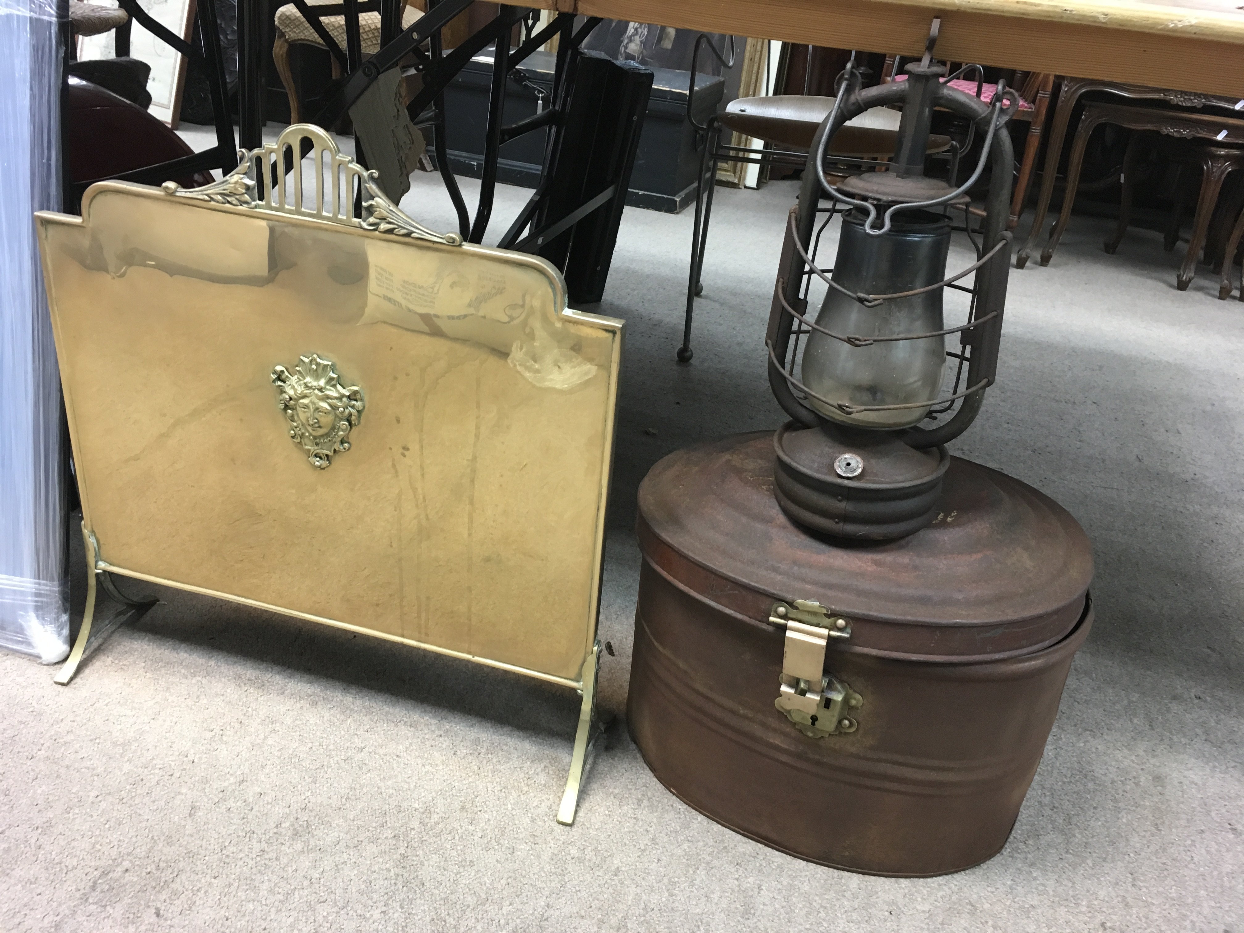 A Victorian metal hat tin with a brass hook, hurricane lamp and a brass fire screen.