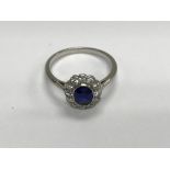 A unmarked white gold Art Deco style sapphire ring surrounded by diamonds size m