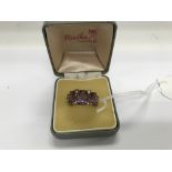 A 9 ct Edwardian ring inset with three large amethyst stones and small cut diamonds