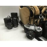 A camera bag, two Makinon lenses, a Minolta XG-1 camera and other photographic accessories.