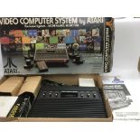 A boxed Atari CX2600 games console and accessories