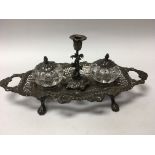 A Victorian silver silver desk stand inset with a pair of glass ink bottles and a single candle