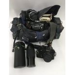 A bag of cameras including a Minolta and a Cosina with lens