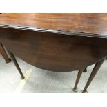 A mahogany drop leaf table the twin flap top above turned legs on pad feet