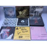 A collection of signed Einsturzende Neubauten CDs plus a record bag embossed with their logo.