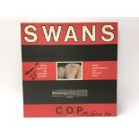 A signed copy of Cops by Swans, the cover bearing