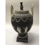 A large 19th Century Wedgwood black basalt classical urn sprig decoration with raised figures.