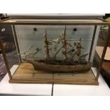 A wooden model of a sailing ship in a glass case, approx 72cm x 49cm.
