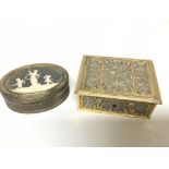 A Continental white metal and parcel gilt box of oval shape inset with a classical picture and one