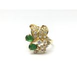 A ladies 18ct gold ring set with CZ's and two emeralds, ring size O/P, weight approx 5 grams.