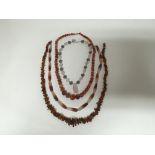 A group of necklaces to include a hard stone amber and agate necklace, an agate necklace, a