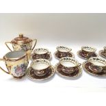 A Limoges porcelain tea set eight cups and saucers with panels of flowers and foliage. No damage.