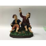 A pair of figures to include a Spelter figure group of two young boys and a cast metal figure of a