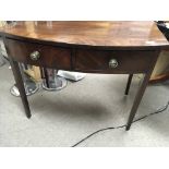 A late George III Mahogany side table with a cross-banded top fitted with two drawers with brass