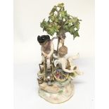 A 19th century Quality Meissen figure group depicting cherubs with a grinding wheel under a tree.