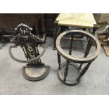 A Victorian cast iron stick stand and a circular wooden stick stand.