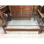 A modern curved glass topped coffee table, measures approx 120cm x 71cm.