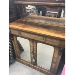 A Victorian rosewood chiffonier the raised mirrored back above a single drawer and mirrored doors