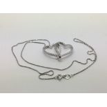 An 18ct white gold double heart pendant set with small diamonds, approx