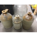 A collection of stoneware bottles and a glass bottle