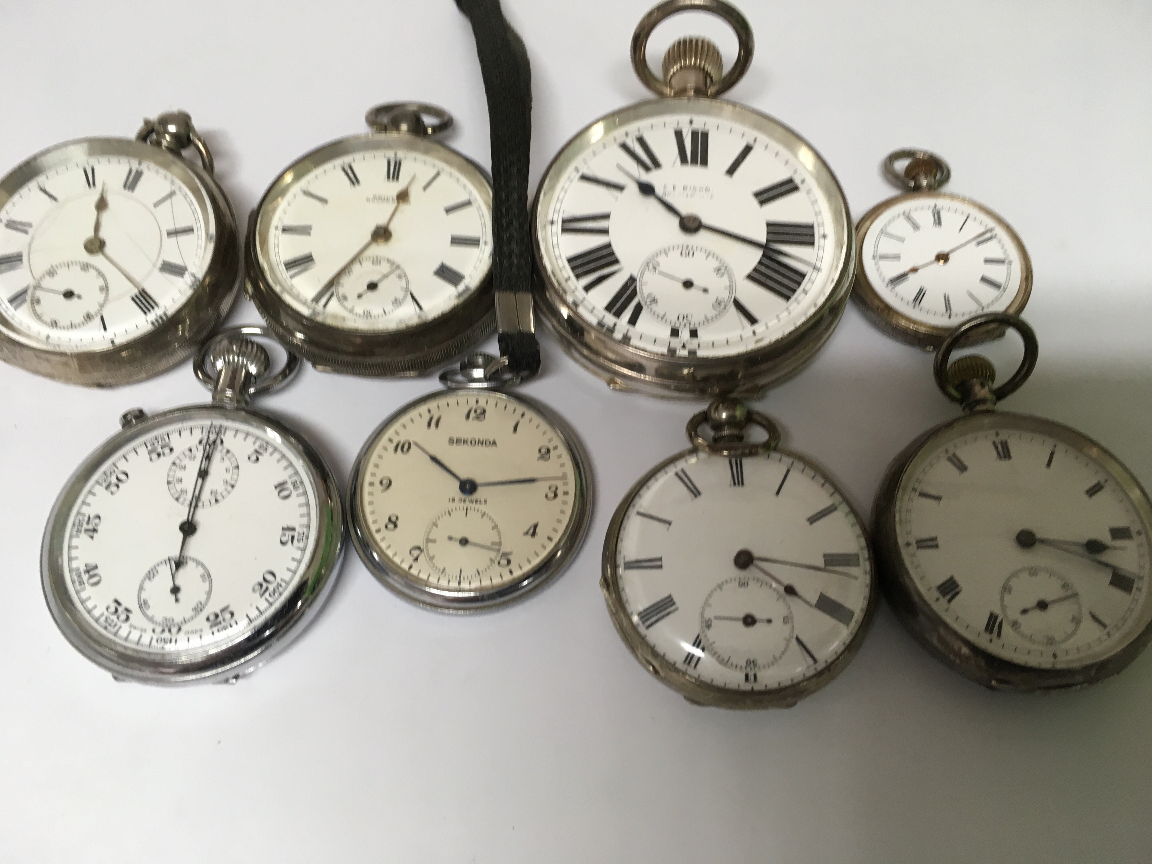 A collection of 7 pocket watches and a stopwatch including silver