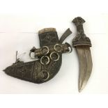 A Middle Eastern, Omani Kanjar dagger having ornate white metal filigree sheath