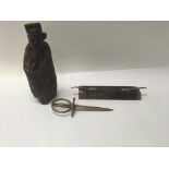 A carved wood oriental figure alongside am Indian designed letter opener with wooden sheath and