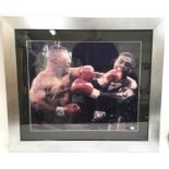 A signed framed photo of Mike Tyson fighting Frank Bruno, bearing Tyson’s autograph in silver ink.