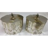 A pair of shaped and engraved silver plated biscuit barrels.