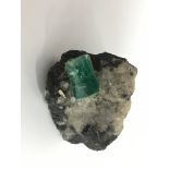 A uncut, rock set emerald