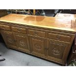 A Chinese hardwood sideboard with four cupboards and drawers. Measures approx 152cm long x 48cm deep