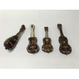 A group of four miniature musical stringed instruments covered in mother of pearl and tortoise