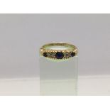 An 18ct gold ring set with three sapphires and two diamonds, approx 2.8g and approx size M.