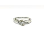 A 9ct white gold ring set with a central set diamond flanked either side by three graduating stones.