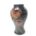 An Early William Moorcroft big poppy pattern vase tube lined on a deep ground. Marks to the base