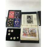 A box containing a collection of silver coins, including Royal Mint uncirculated coin sets.
