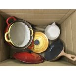 A box containing Le Creuset cooking pans and pots
