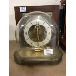 A brass cased modern design clock maker kienhinger West Germany. Under a glass dome and a mahogany